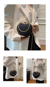 Detail of heart-shaped black sequin evening bag with gold chain and metal handle