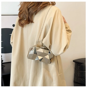 Close-up of a silver geometric evening bag with a metallic finish and chain strap