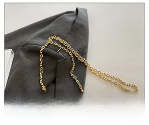 Detailed macro view of the gold seashell-shaped bag texture and metallic chain strap