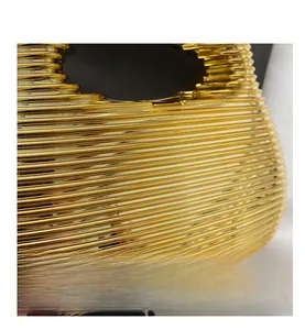 Detail shot of golden metal clutch with horizontal wave pattern and reflective finish