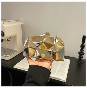 Detailed view of a gold geometric faceted evening clutch bag with shiny metal finish