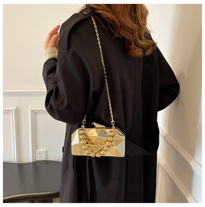Detail of gold geometric evening bag with metallic mirror finish and bead handle