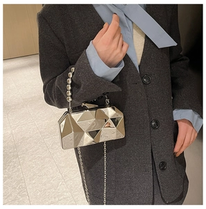 Detail view of silver geometric evening bag with metallic bead handle and chain strap
