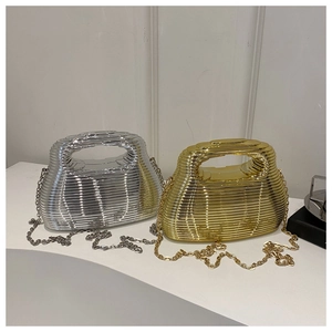 Detail of gold and silver acrylic handbags with layered textures and metallic chains