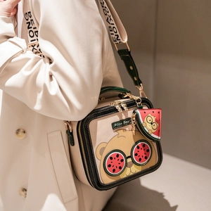 Cartoon bear crossbody bag with watermelon charm and wide lettered strap