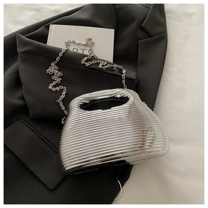Close-up of a silver acrylic clutch with wavy texture and metallic chain strap