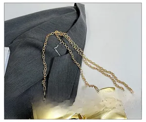 Close-up of golden metal chain strap and mirrored texture on elegant women box bag