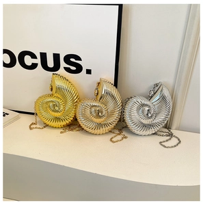 Three conch-shaped evening clutch bags in gold, silver and champagne with metal chain straps