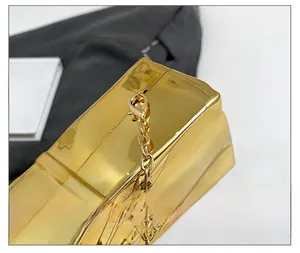 Detail shot of the golden metal chain and lobster clasp on a modern evening clutch bag