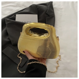 Detail of gold rippled acrylic evening bag with fine chain and metallic handle texture