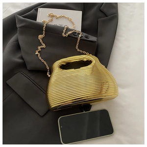 Detailed view of golden acrylic clutch with ripple texture and detachable metal chain