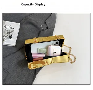 Interior view of gold bow clutch showing storage for phone, cushion, and lipsticks