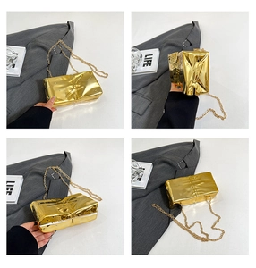 Detailed close-up of a gold metallic clutch bag with unique wrinkled texture and chain strap
