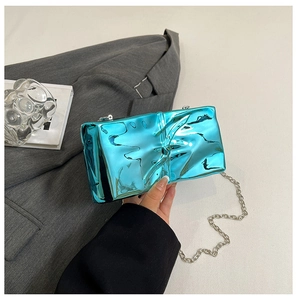 Close-up of bright blue metallic evening clutch with crinkled texture and silver chain strap