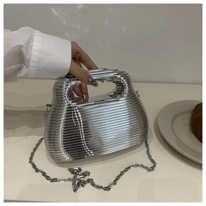 Macro view of silver acrylic handbag with horizontal wave texture and metal chain strap