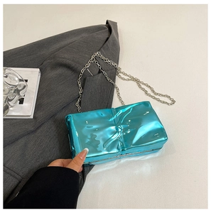 Detail of blue electroplated box bag featuring a unique wrinkled texture and silver chain
