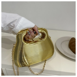 Detail of gold metallic clutch bag featuring horizontal ripple texture and chain strap