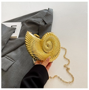 Close-up of golden shell clutch bag with metallic texture and removable chain strap