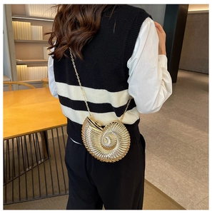 Detail view of a gold nautilus shell evening bag with elegant metallic finish and chain