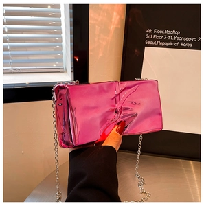 Close-up of metallic pink crossbody box bag with unique crinkled texture and silver chain