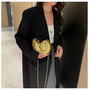 Exquisite gold nautilus shell clutch bag with a metallic chain shown on a model