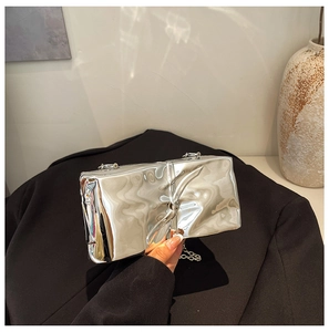 Close-up of silver mirror acrylic evening bag with liquid metal pleats and chain strap