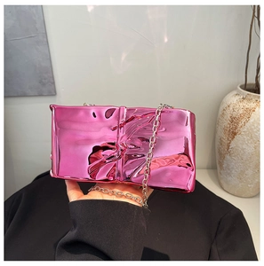 Detail of metallic pink crossbody bag with pleated texture and silver chain strap