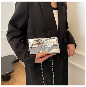 Detail view of silver pleated acrylic box bag with metallic liquid effect and chain