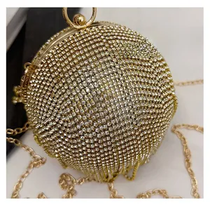 Dettaglio borsa da sera rotonda color oro con strass scintillanti e manico ad anello