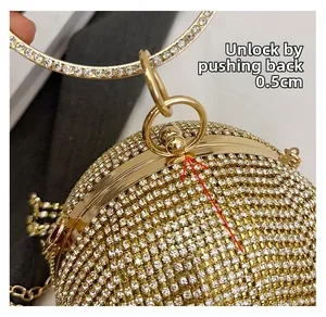 Dettaglio della chiusura in metallo dorato di una pochette da sera tonda con strass