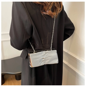 Silver mirror crossbody box bag with metallic texture shown on a model
