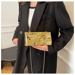 Detailed view of a gold mirrored fold texture clutch bag with elegant chain strap