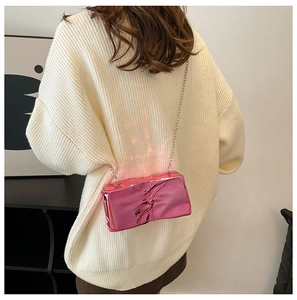 Pink metallic crossbody bag with textured finish and silver chain on model
