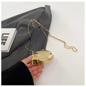 Detailed macro shot of a gold fish-shaped metal clutch bag with scale textures