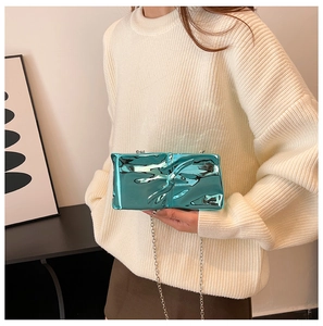Detail of metallic cyan clutch bag featuring unique wrinkled texture and silver chain
