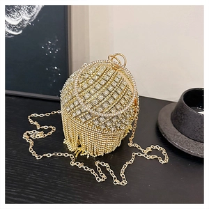 Dettaglio della borsa da sera sferica con strass, nappe lucide e manici tondi dorati