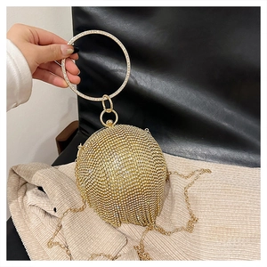 Dettaglio della borsa da sera sferica con strass dorati, manico tondo e catena