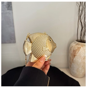 Detailed close-up of fish-shaped golden metal mini bag with textured scales and bead chain
