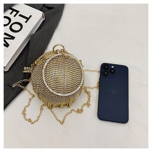 Dettaglio della borsa da sera sferica con strass dorati e manico ad anello chic