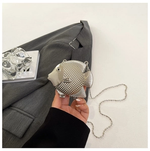 Detailed macro view of silver fish-shaped handbag featuring intricate scale textures