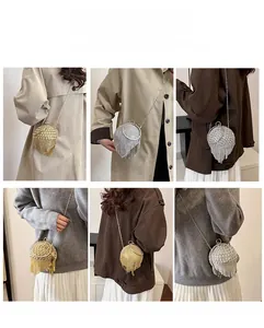 Dettaglio della borsa da sera rotonda con strass, lunghe nappe e tracolla a catena