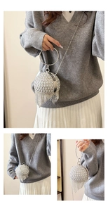 Dettaglio ravvicinato della pochette a sfera con strass scintillanti e nappe argentate