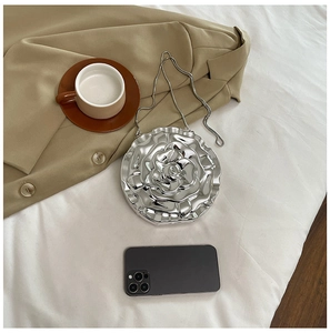 Detailed view of silver rose-shaped acrylic clutch with metallic petals and chain