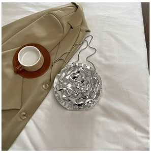 Macro view of a 3D silver rose-shaped acrylic evening clutch bag with chain strap