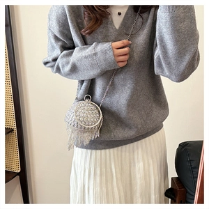 Dettaglio borsa a sfera argento con strass, nappe metalliche e tracolla a catena