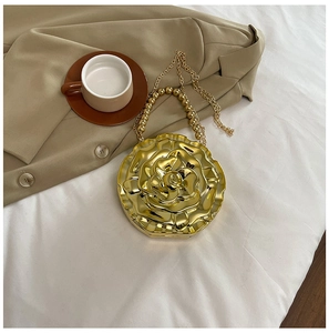 Detail of golden rose-shaped acrylic evening bag with beaded handle on beige blazer