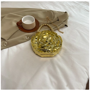 Detailed view of a golden rose-shaped metal clutch bag with beaded handle and chain