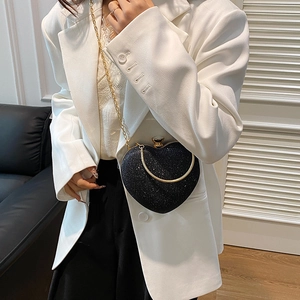 Sparkling black heart shaped evening clutch bag with gold chain strap and metal clasp