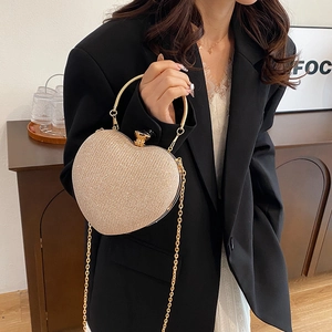 Elegant champagne gold heart-shaped evening clutch bag with glitter finish and chain strap