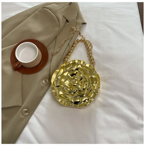 Close-up of gold 3D rose acrylic evening bag with beaded handle and metal chain
